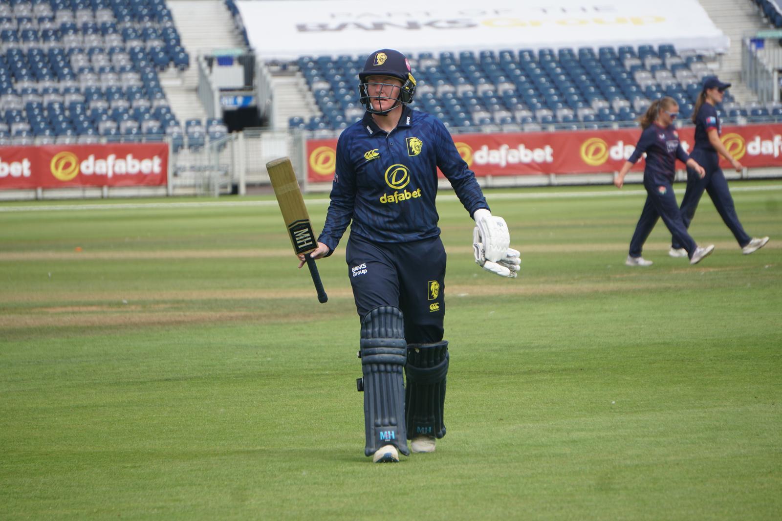 Hollie Armitage raising her bat while leaving the field after a fine knock of 111 in Durham's 89-run triumph over Lancashire.